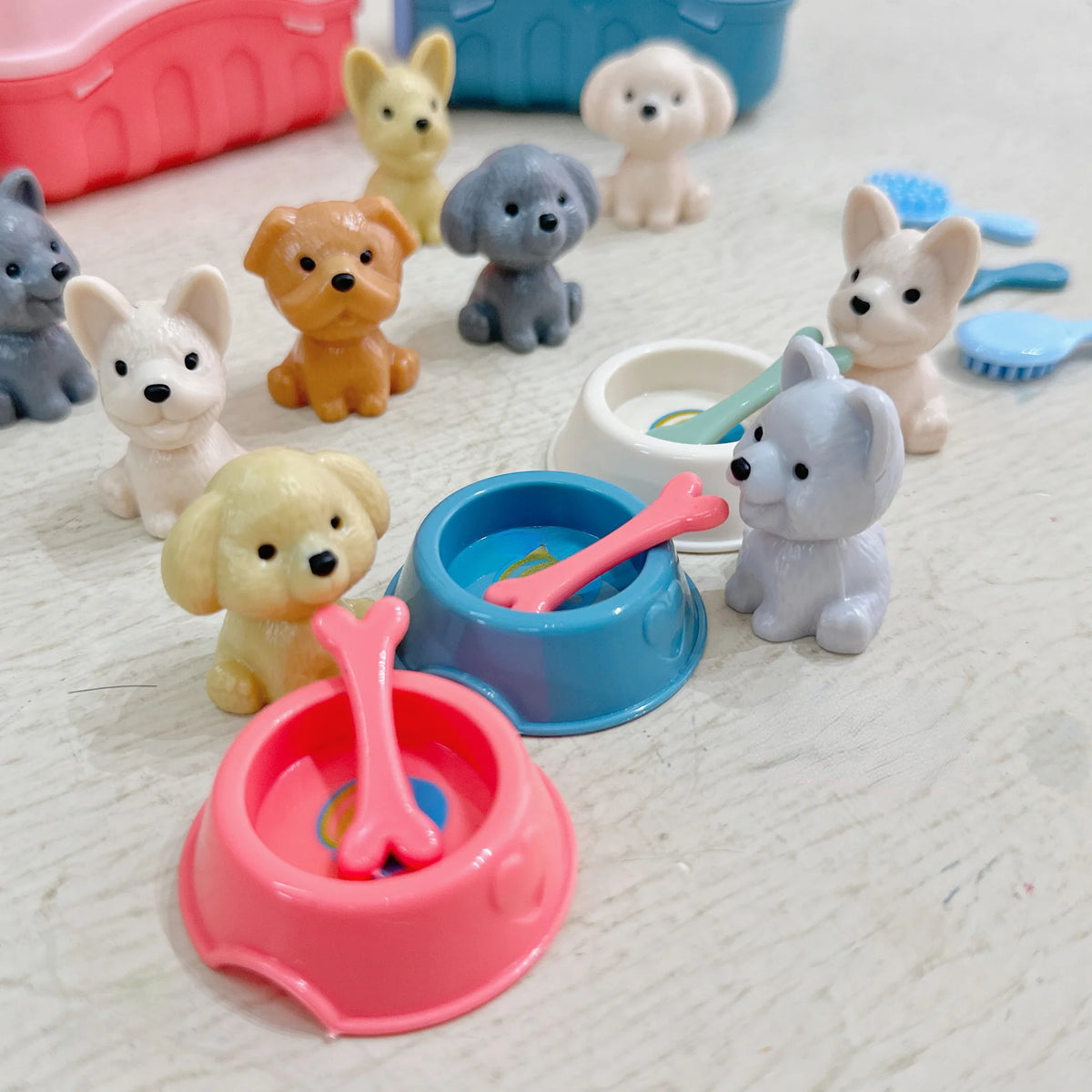 A collection of eight cute dog figures in various colors and poses arranged on a light surface.