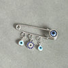 Elegant gold and silver evil eye brooch pin featuring multiple blue and white eye charms