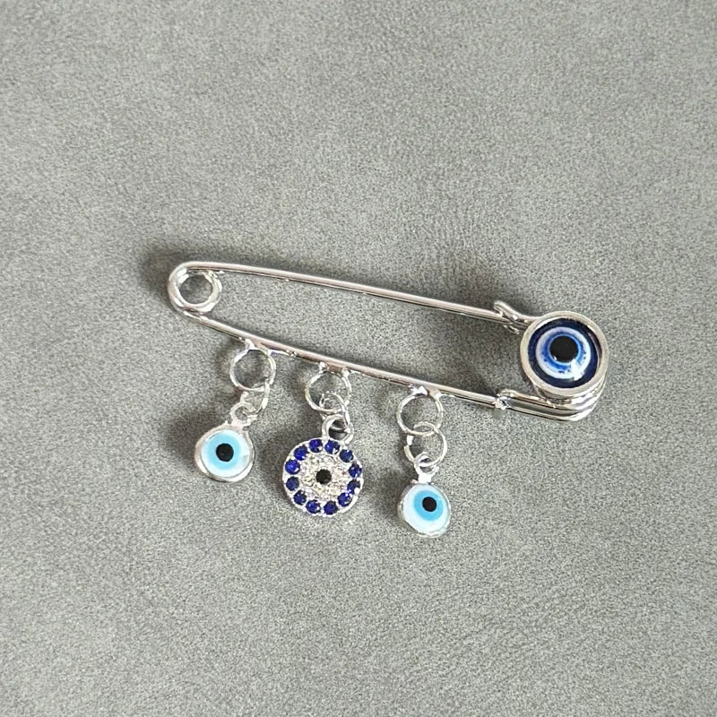 Elegant gold and silver evil eye brooch pin featuring multiple blue and white eye charms