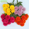 A bouquet of artificial flowers featuring yellow, pink, and orange hydrangeas and camellias.