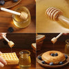 A set of natural wood honey dipper sticks is shown dripping golden honey onto a waffle and a donut.