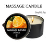 A black jar of orange massage candle with a lit wick and sliced oranges visible inside.