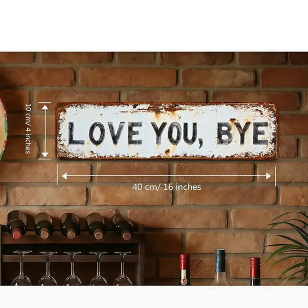 A weathered metal sign reading LOVE YOU BYE mounted on a brick wall with barware below.