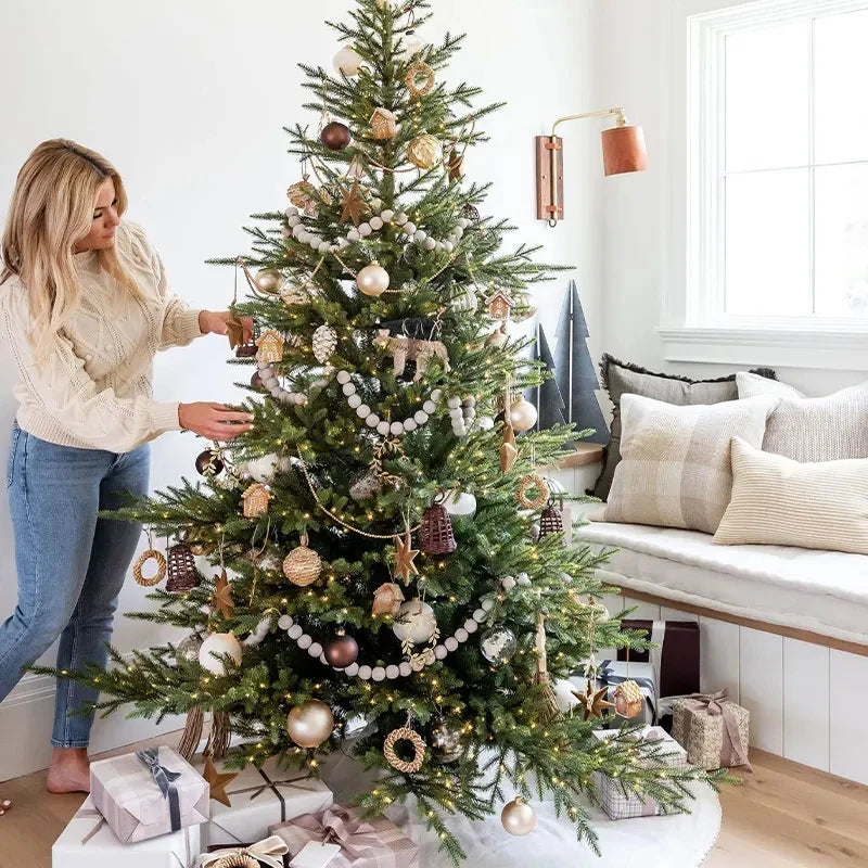 A decorated Christmas tree adorned with various ornaments and lights in a bright room.