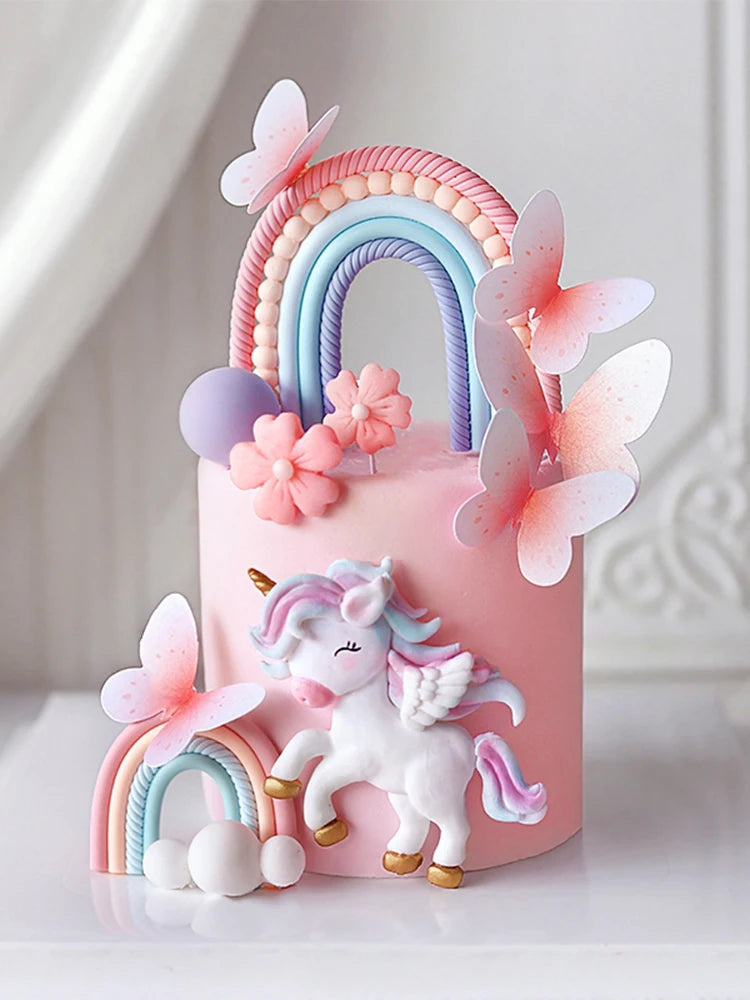 Pink unicorn theme cake topper set featuring a rainbow arch and pink butterfly decorations
