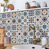 A decorative tile backsplash featuring blue, white, and brown geometric patterns on a kitchen wall.