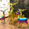 A set of two foil balloons shaped like deer in iridescent gold and purple colors.