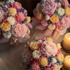 A collection of floral silicone candle molds featuring pink, yellow, and white rose, peony, and camellia shapes.