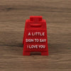 A red 3D printed letter sign ornament with the text A LITTLE SIGN TO SAY I LOVE YOU engraved on it.