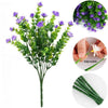 A bundle of purple faux floral plants with green stems and leaves for outdoor decor.