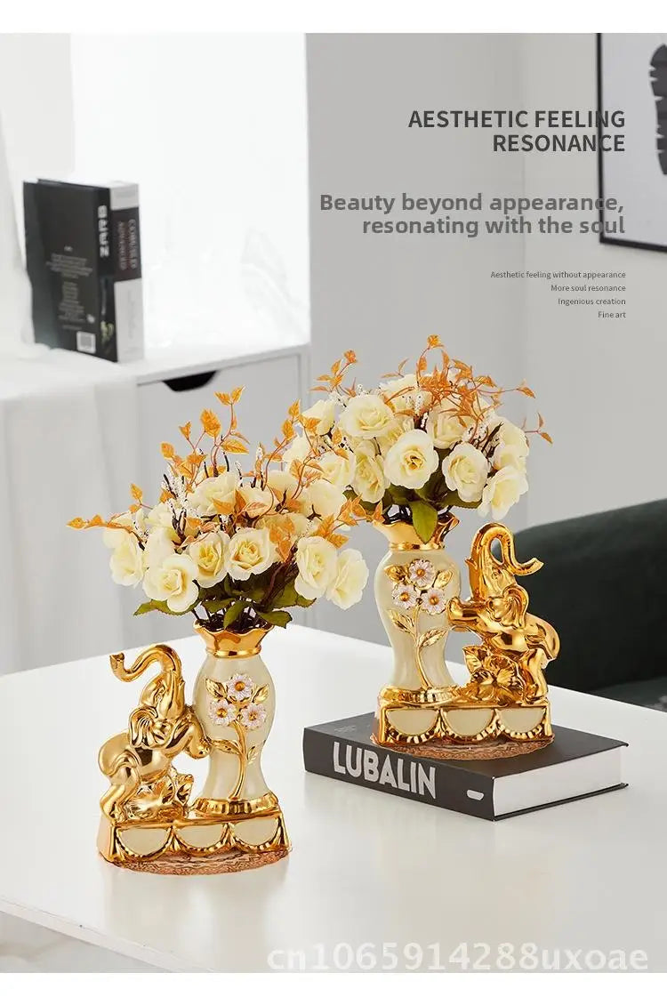 A pair of golden swan ceramic vases displayed on a white table with floral arrangements.