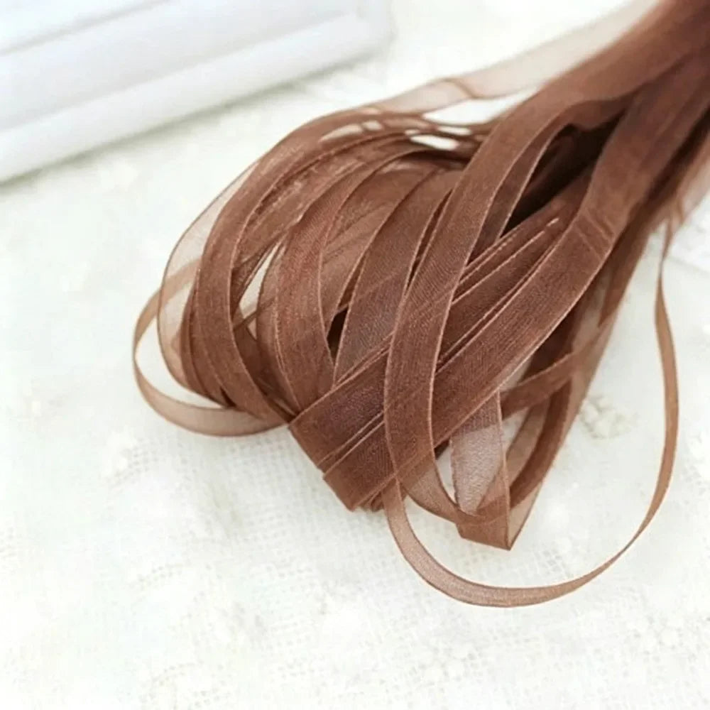A bundle of 10 yards of brown decorative fishtail yarn ribbon laid on a white surface.