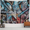 A large tapestry featuring abstract urban graffiti art in shades of blue, black, red, and gold on a wall.