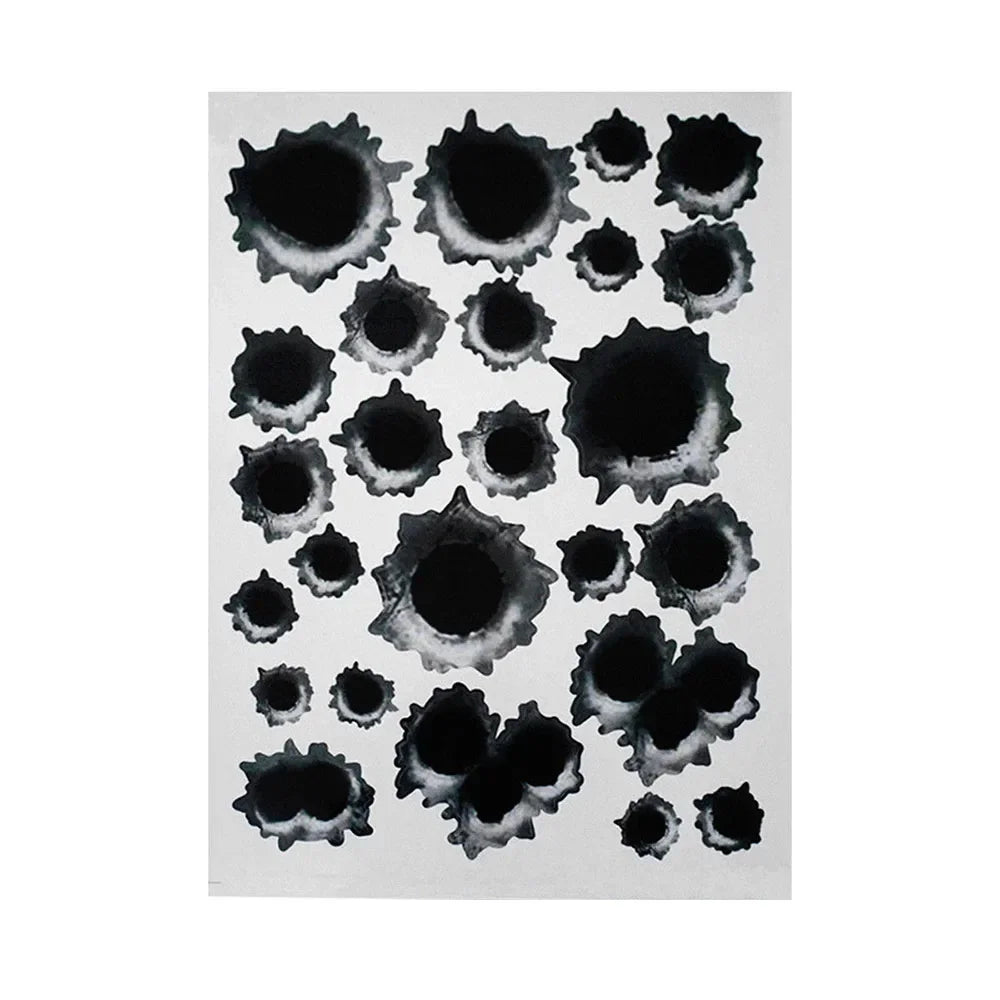 A collection of black, irregular bullet hole shaped stickers on a white background.