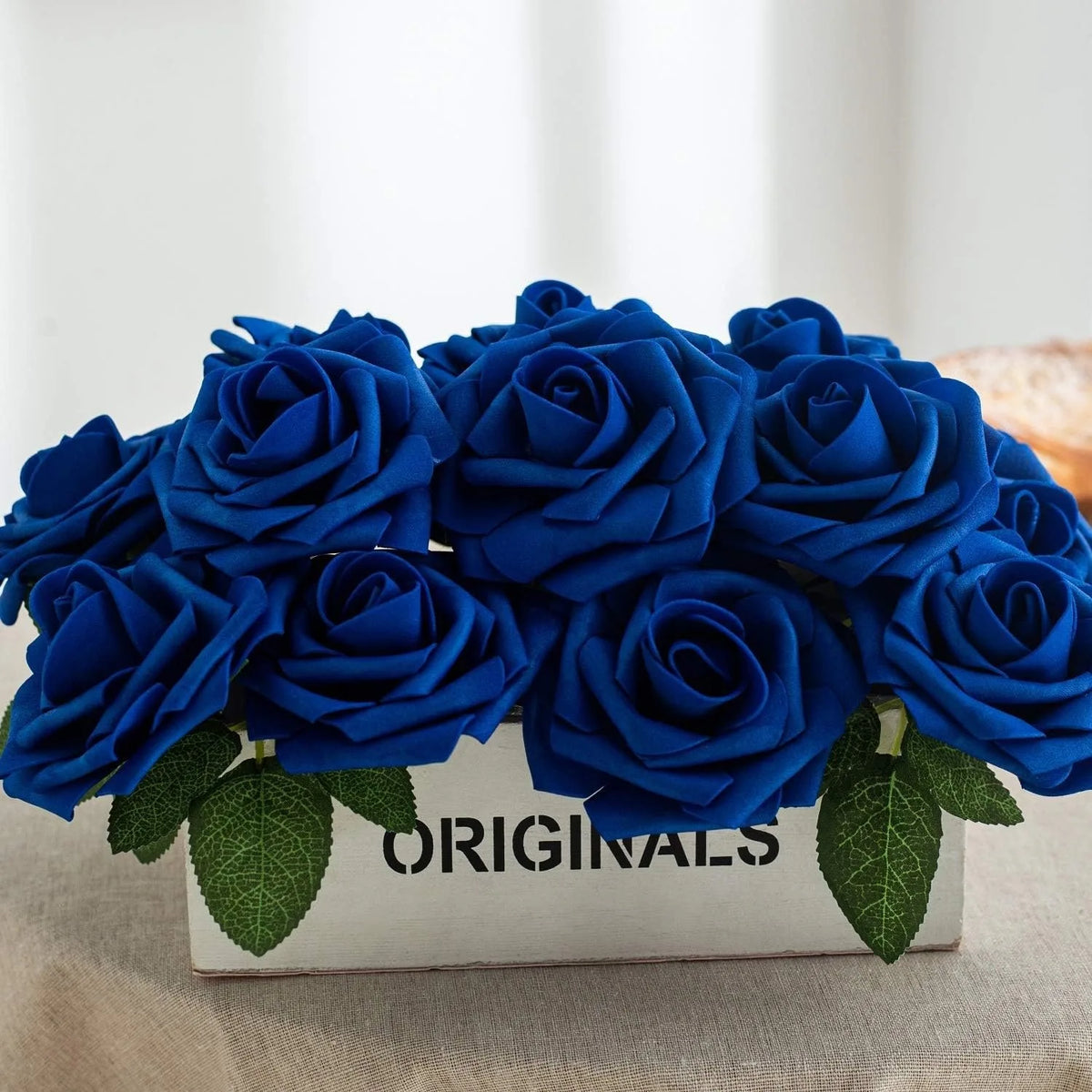 A bouquet of deep blue artificial foam roses displayed in a wooden box.