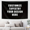 A black tapestry featuring white text that reads Customize Tapestry Your Design Here, displayed above a light-colored sofa.