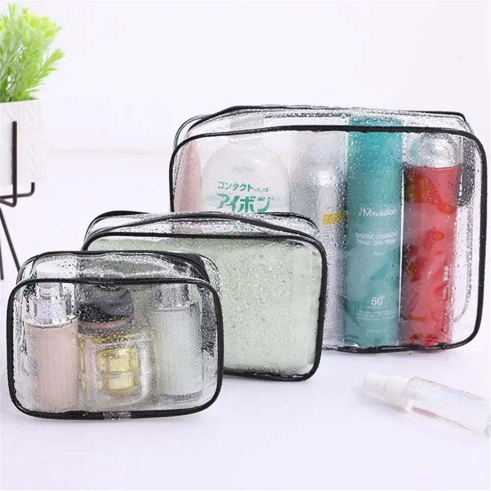 A clear waterproof toiletry bag with a black frame is shown, containing various cosmetic products.