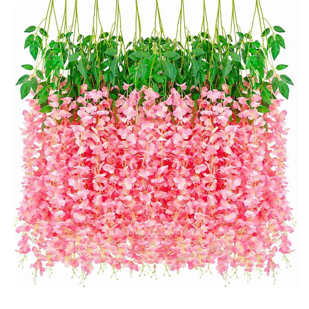 A dense display of pink artificial wisteria flowers hanging down, surrounded by green foliage.