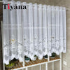 White lace mesh sheer curtain hanging on a rod, featuring delicate floral embroidery.