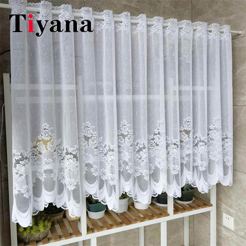 White lace mesh sheer curtain hanging on a rod, featuring delicate floral embroidery.
