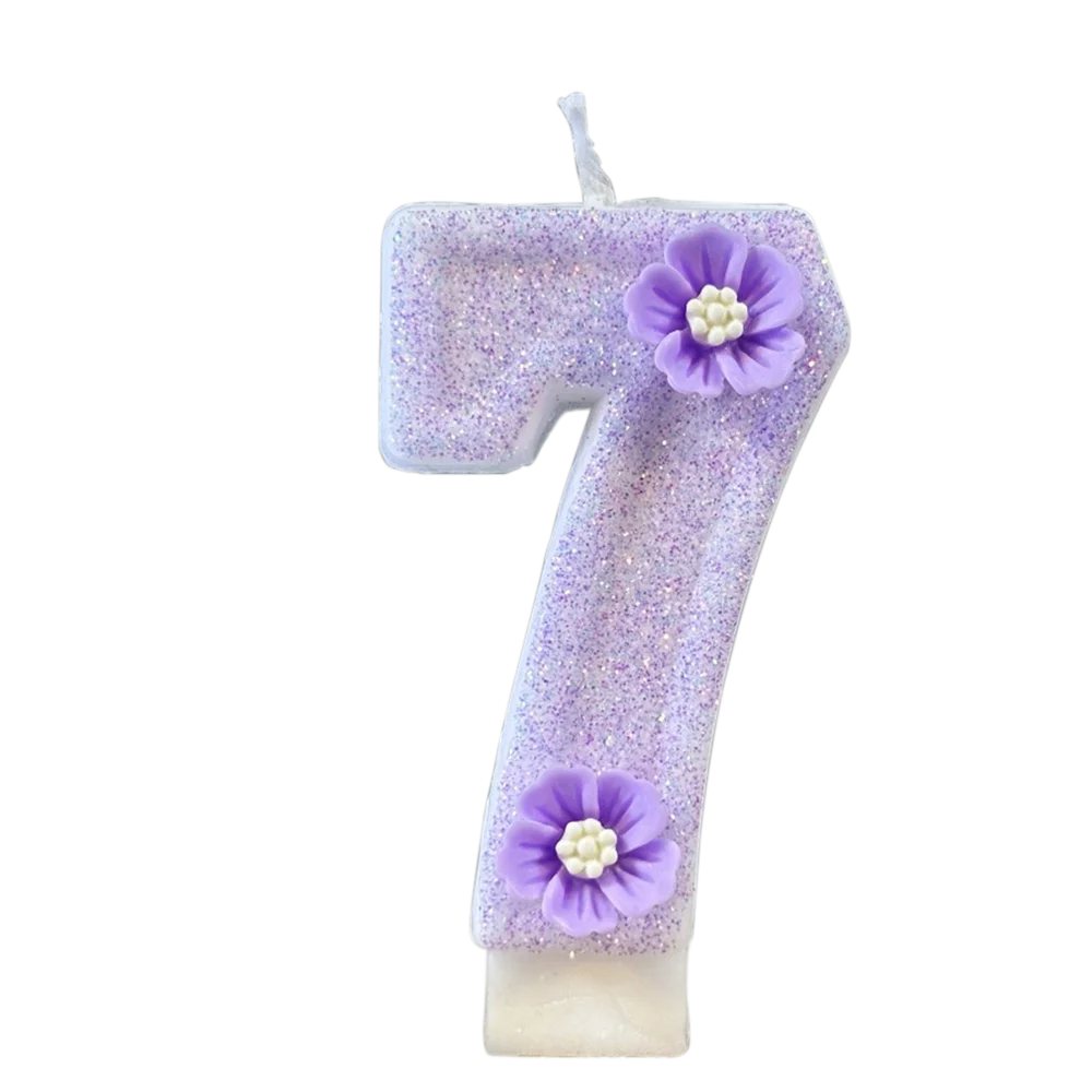 A purple sparkling number candle shaped like the number 7 with a flower decoration.