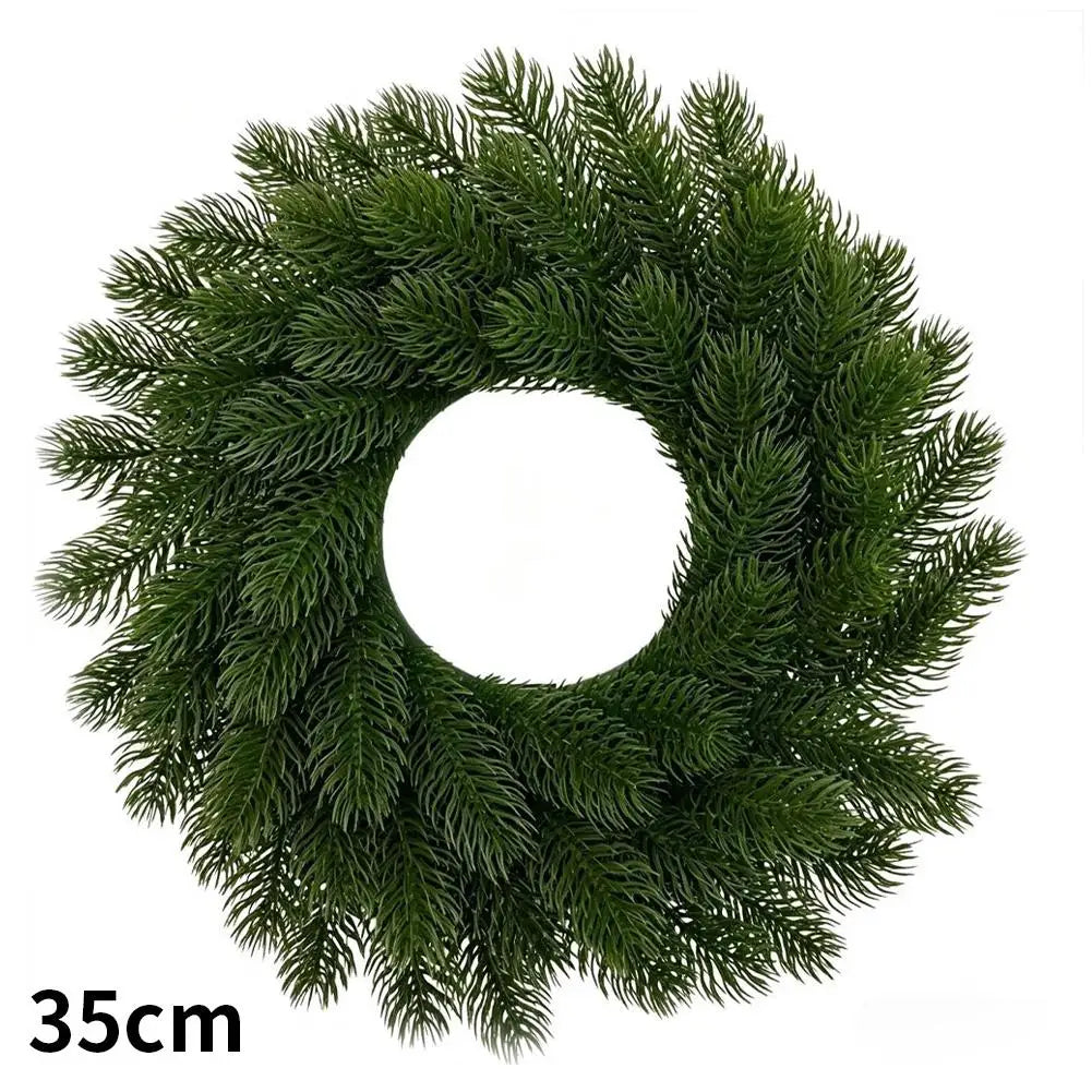 A green artificial Christmas wreath with red berries and a velvet bow.