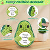 A green crocheted avocado shaped like a cute face with positive affirmations cards and a small potted avocado doll.