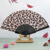 A leopard print folding hand fan with a black handle displayed against a light background.