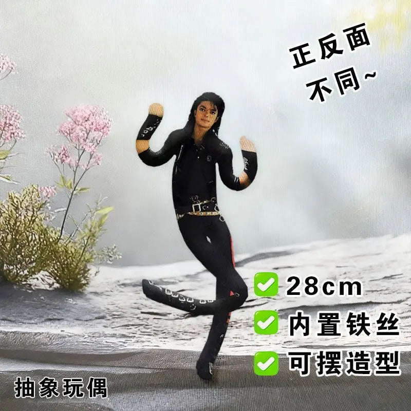 A black collectible plush doll of Michael Jackson in a dynamic pose, shown against a snowy background.