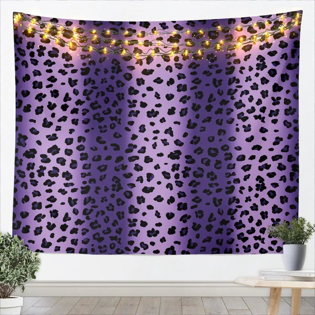 A purple leopard print tapestry wall hanging decorated with warm string lights.