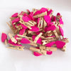 A pile of small pink and magenta wooden photo clips used for crafts and display.