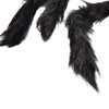 A close-up of a black plush spider decoration with long, dark synthetic spider legs.