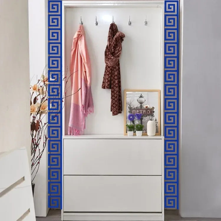 A white cabinet with blue decorative trim displays a pink scarf and a brown shawl.