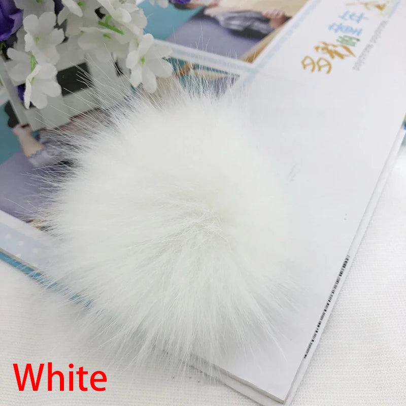 Pompon en fausse fourrure blanche, boule de cheveux, sur fond blanc.