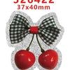 Silver glitter Christmas acrylic charms shaped like cherries with a black and white gingham bow detail