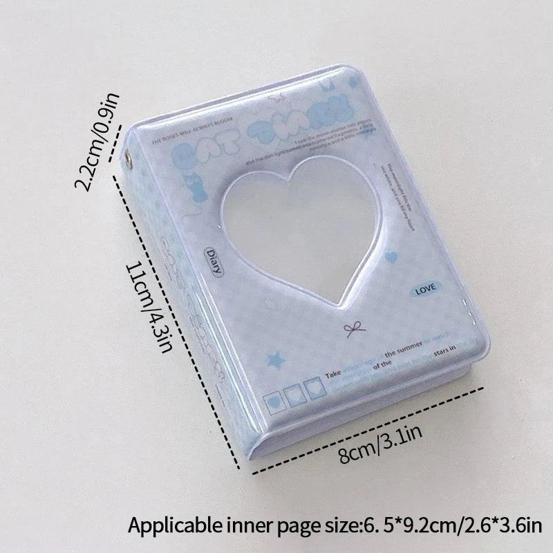 A clear plastic photo card album binder with a heart-shaped window and decorative elements.