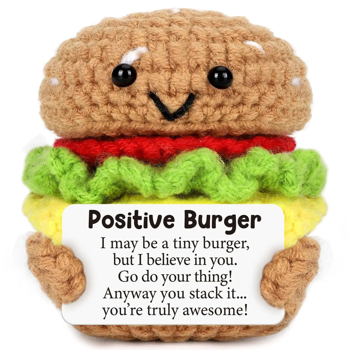 A brown crocheted burger doll with a smiling face and a card that says Positive Burger