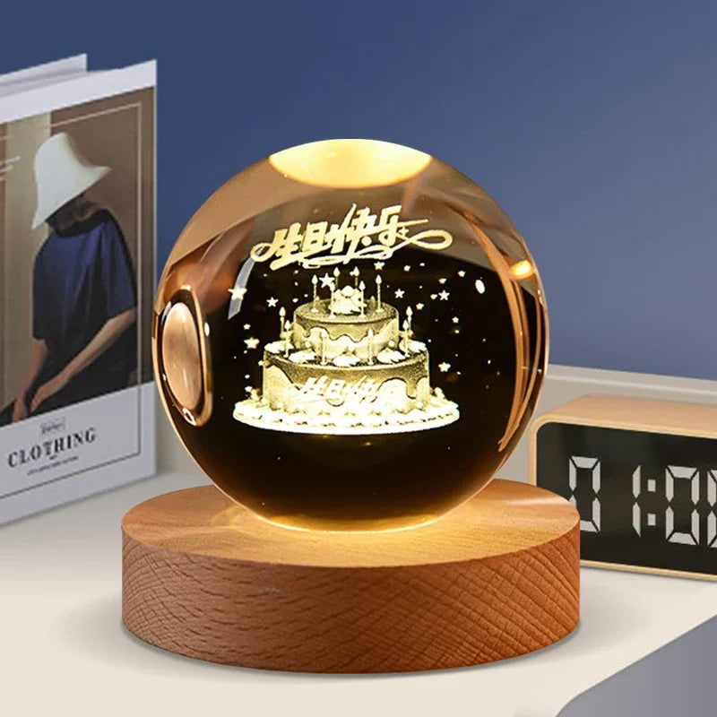 A round amber crystal ball decoration with a dark interior and gold lettering resting on a wooden base.