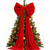 A velvet red Christmas tree bow with long draping tails decorating a green fir tree.