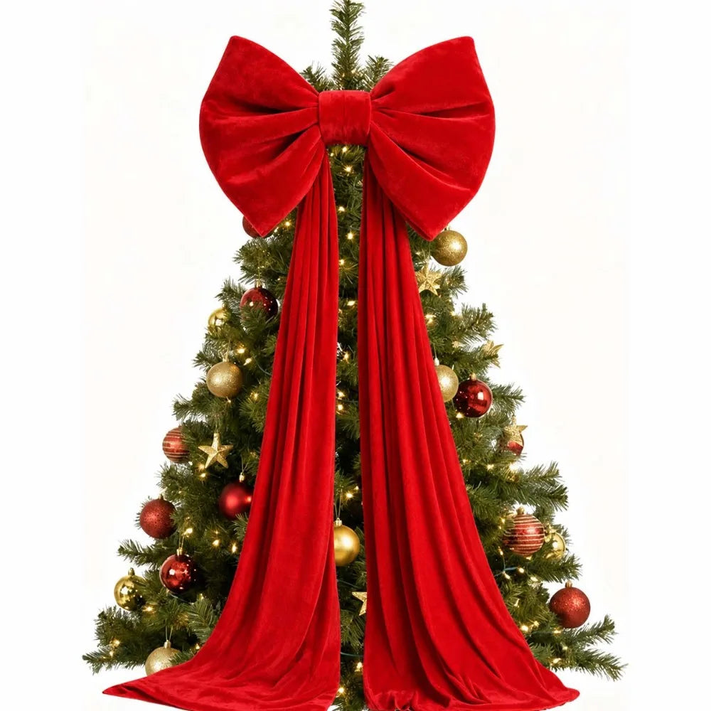 A velvet red Christmas tree bow with long draping tails decorating a green fir tree.