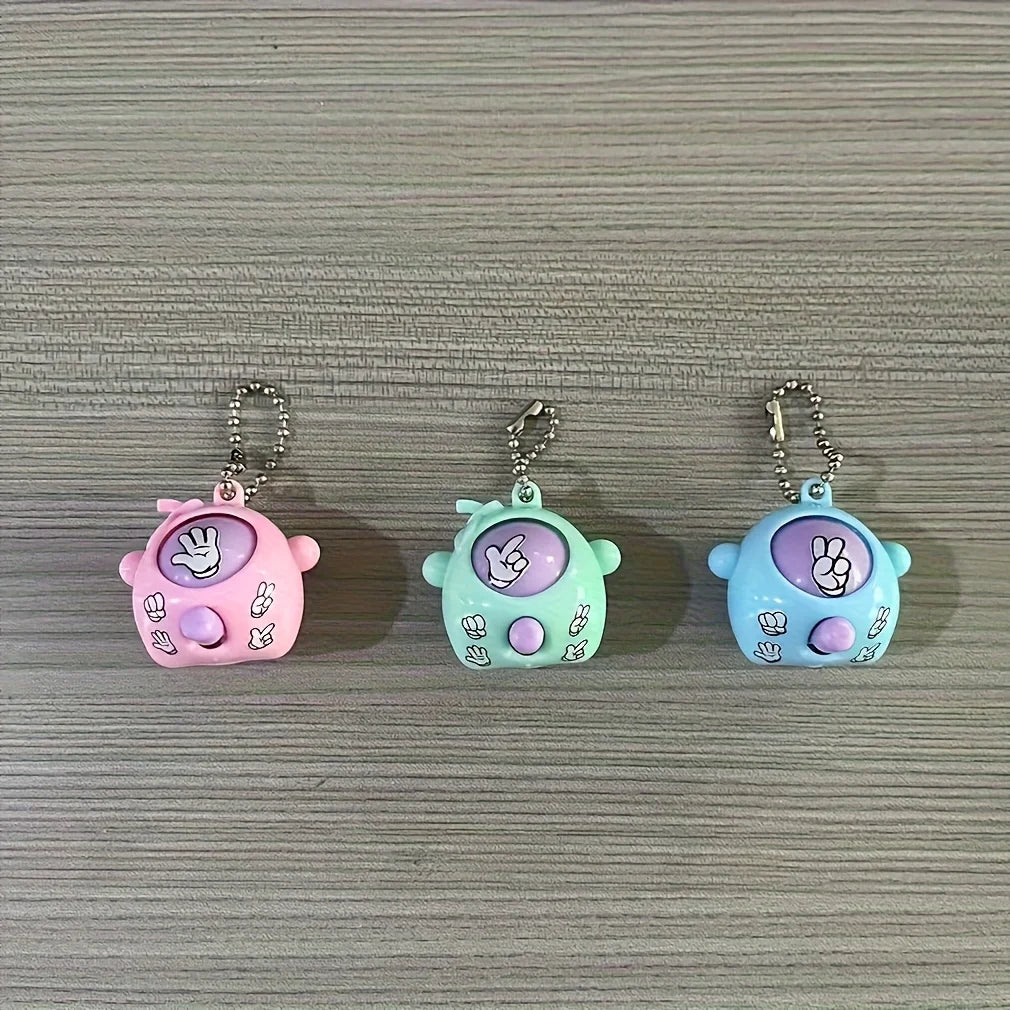 Three colorful silicone keychains shaped like a pink, green, and blue frog for party favors