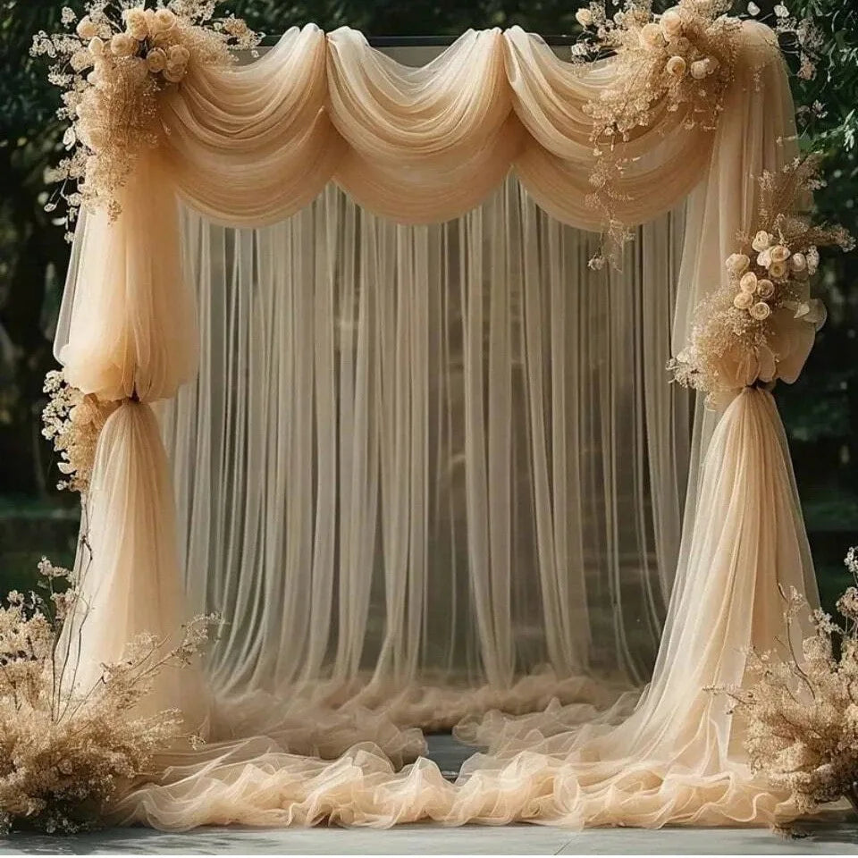 Elegant beige tulle backdrop with draped fabric and floral accents for events