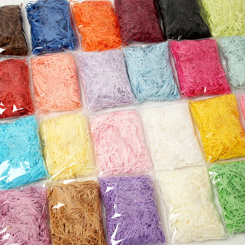 A variety of vibrant crinkle paper shreds in colors like pink, orange, purple, yellow, and green are displayed in clear packa
