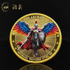 A gold medal coin featuring a winged warrior design with the text The Archangel and Michael Watches Over Us