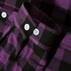 A close-up of a purple and black plaid flannel shirt with white buttons.