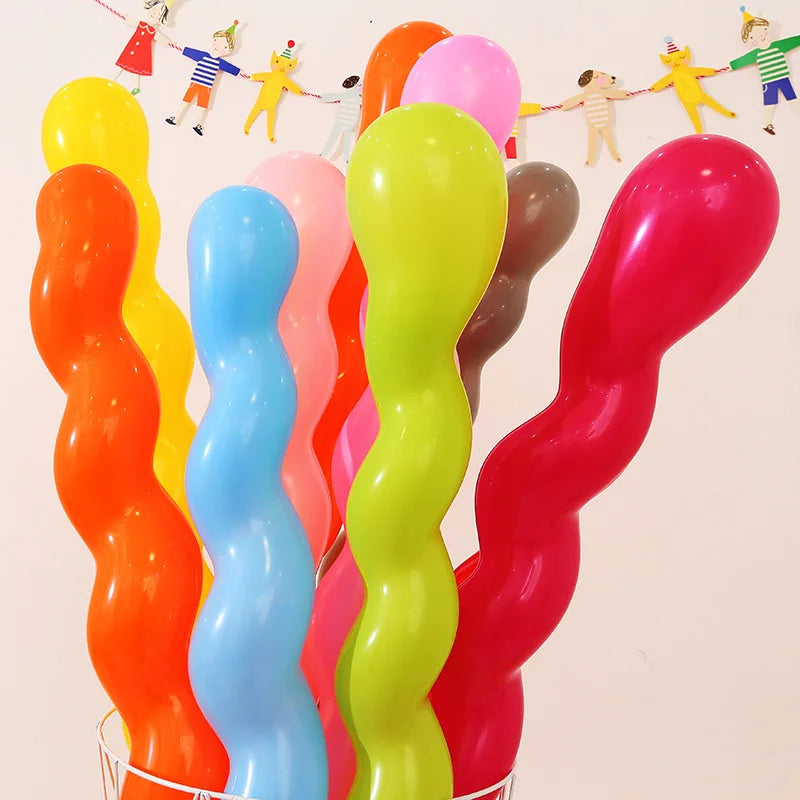 A collection of assorted latex balloons in bright colors like yellow, orange, pink, and blue, arranged vertically.
