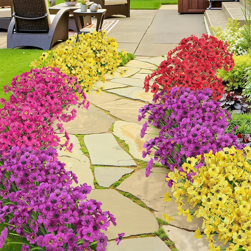 A vibrant display of silk artificial flowers in shades of pink, purple, and yellow arranged in a garden pathway.