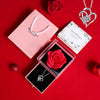 A gift set featuring a preserved red rose and a heart-shaped silver necklace on a red background.