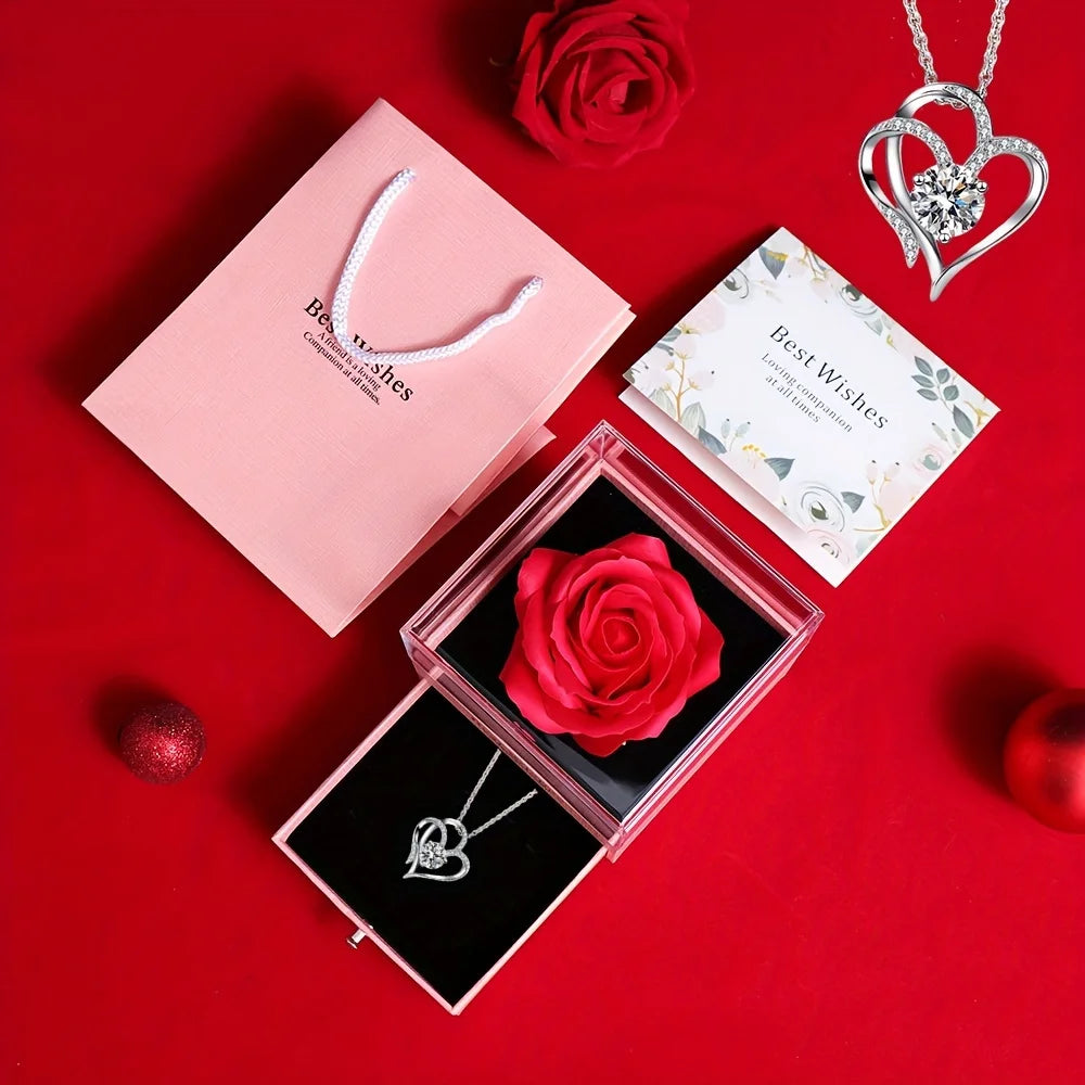 A gift set featuring a preserved red rose and a heart-shaped silver necklace on a red background.