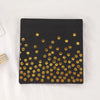 A black rectangular box featuring a pattern of gold polka dots.